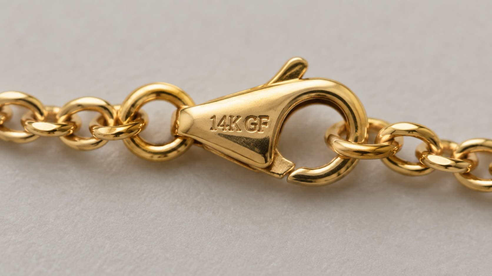 Gold chain clasp engraved with a 14K GF stamp indicating gold filled jewelry