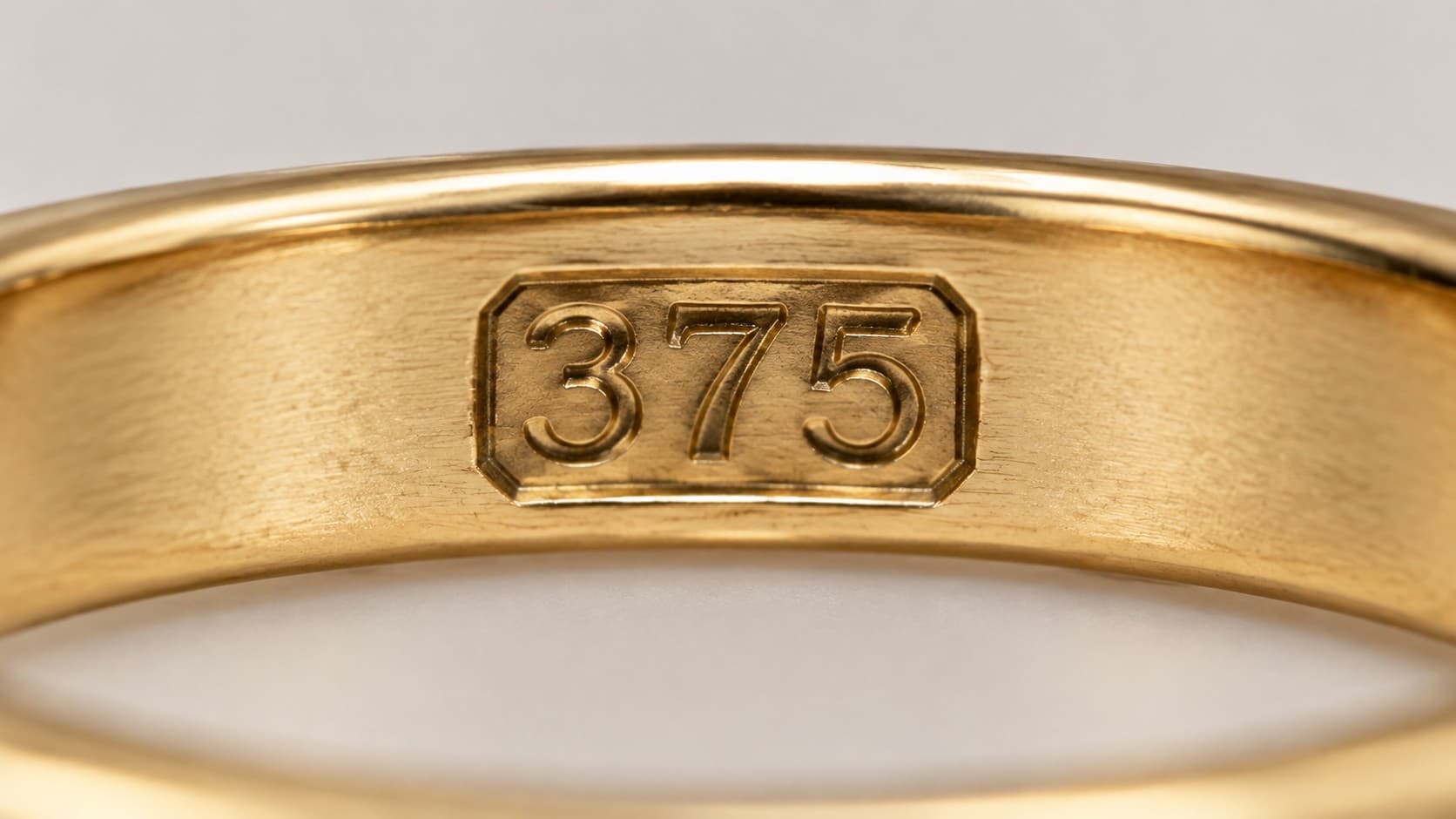 Close-up of a 375 stamp hallmark inside a polished 9K gold ring band