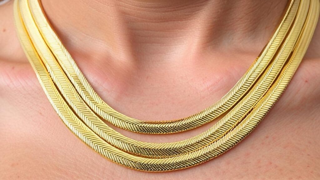 Triple-layered gold herringbone chain necklaces from the 1980s, showcasing the era's popular metal style and layering technique