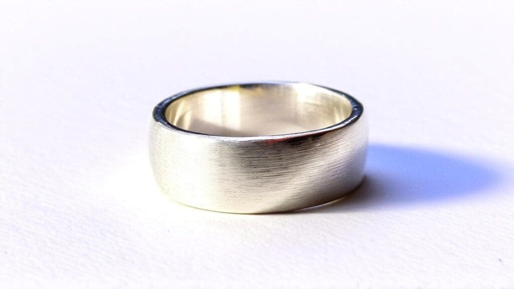 Minimalist chunky silver band ring with brushed finish, representative of 90s industrial style silver jewelry