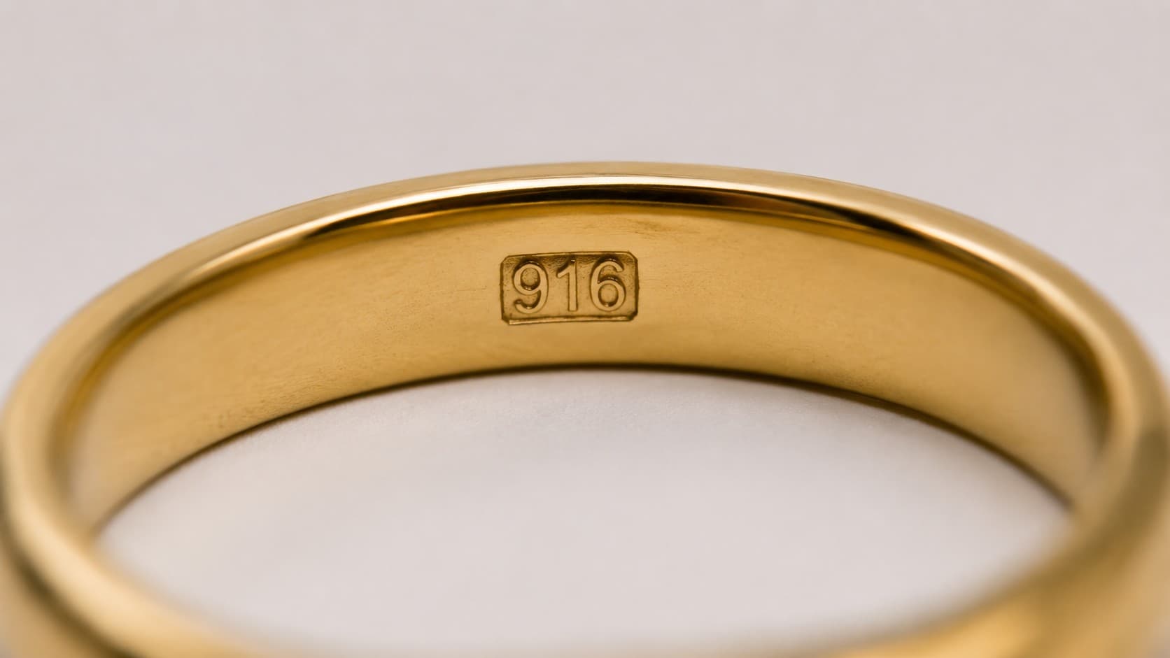 Close-up of a 916 stamp engraved inside a gold ring band
