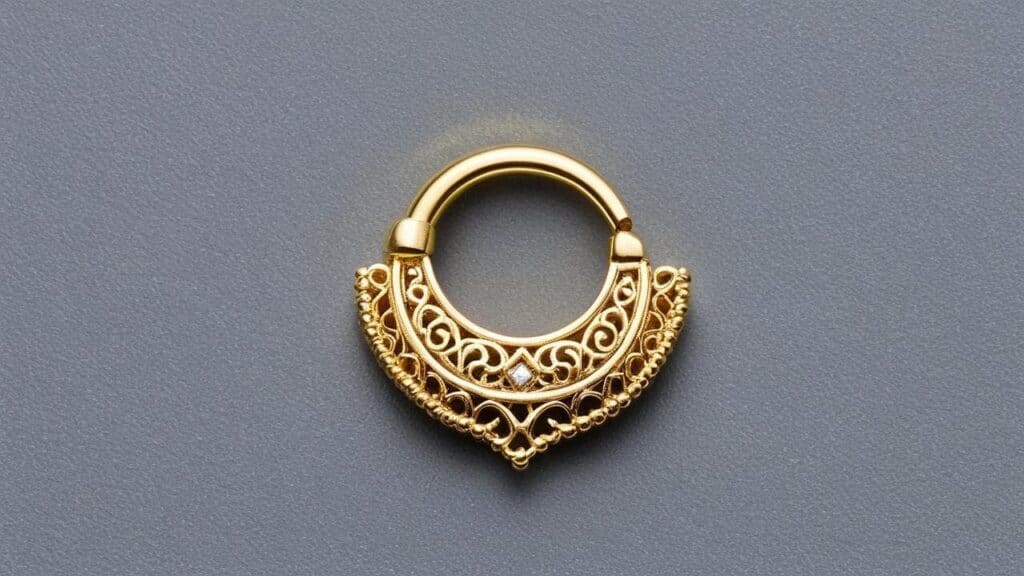 Ornate gold septum ring with intricate filigree pattern and small diamond accent on gray background
