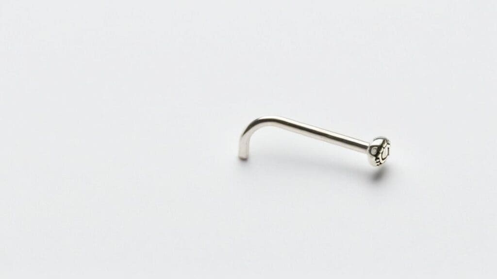 Silver L-shaped nose stud with small decorative end for nostril piercing on white background
