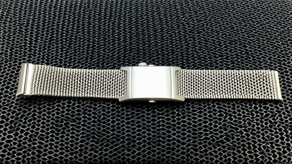 Silver mesh watch band with adjustable sliding clasp mechanism for precise sizing adjustments