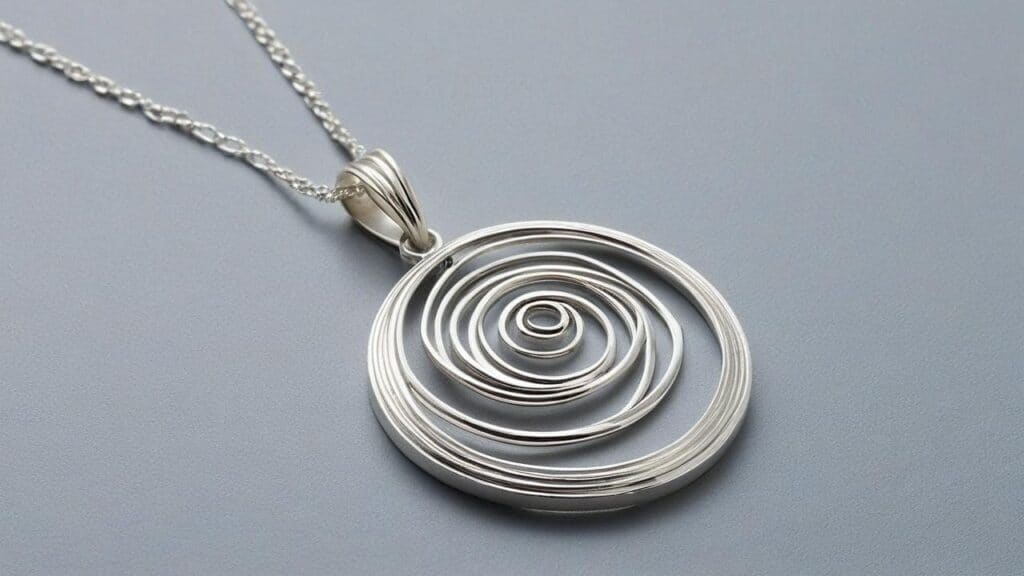 Modern Argentium Silver spiral pendant necklace featuring intricate coil design on neutral gray background
