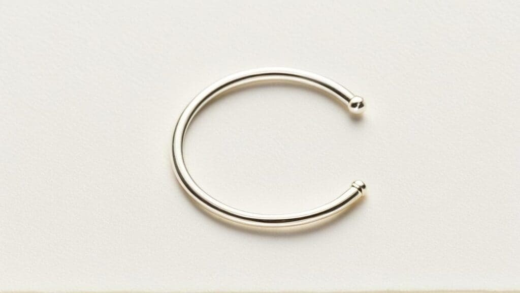 Minimalist silver septum ring with ball ends shown on white background
