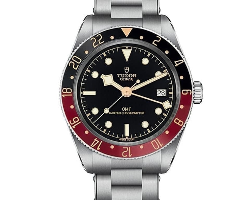 Tudor GMT watch with red and black bezel, black dial, snowflake hands, and stainless steel bracelet representing luxury Swiss dive watch craftsmanship