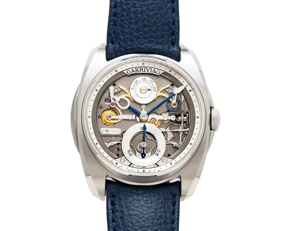 Akrivia AK-06 openworked dial showing power reserve indicator with blue leather strap