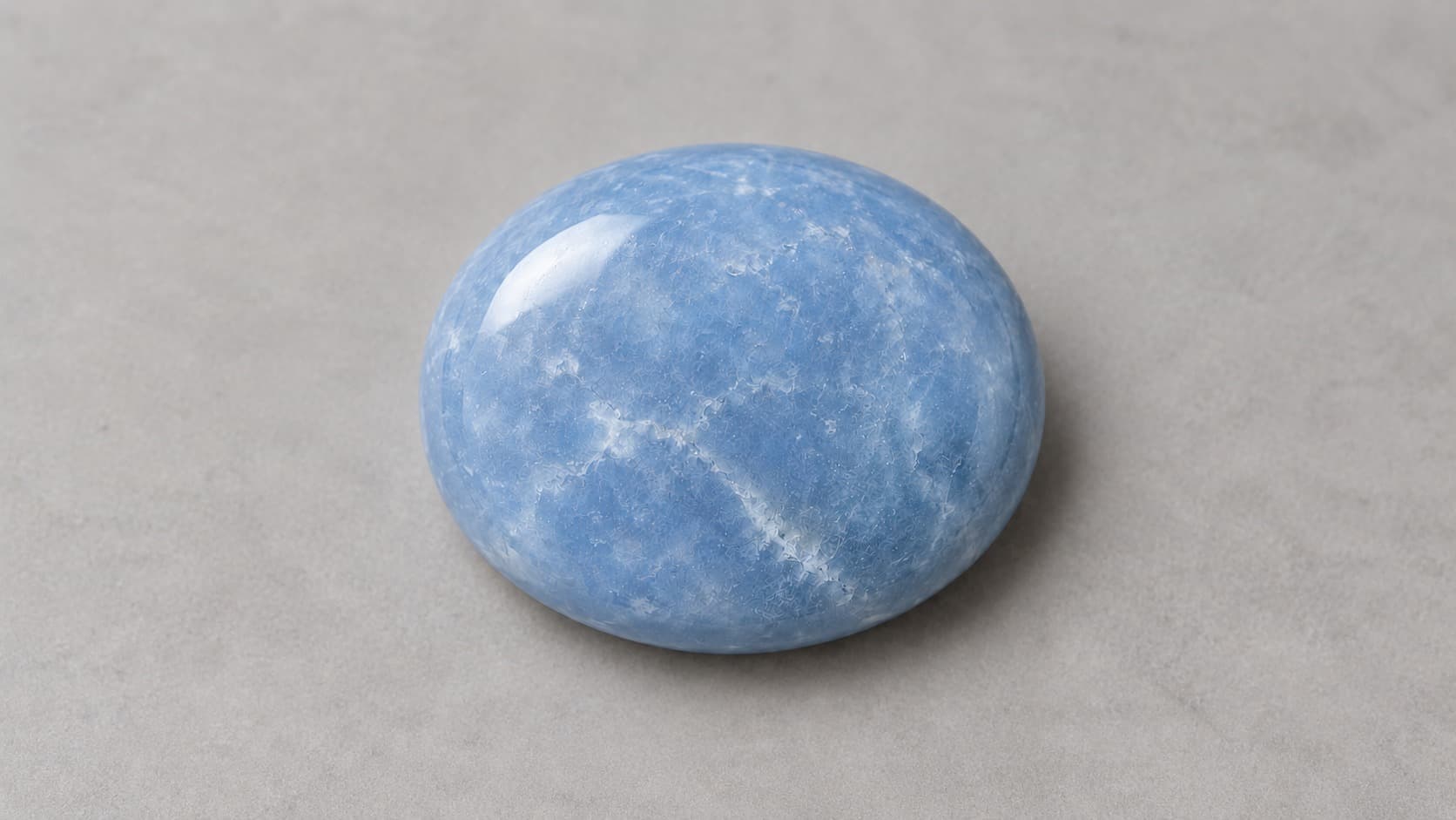 Close-up of a smooth polished angelite gemstone showing natural blue-gray texture