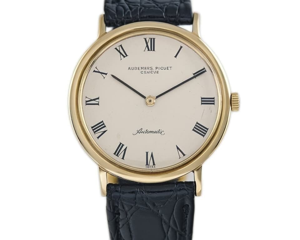 Vintage Audemars Piguet gold dress watch with cream dial, Roman numeral hour markers, black crocodile leather strap, and traditional round case design