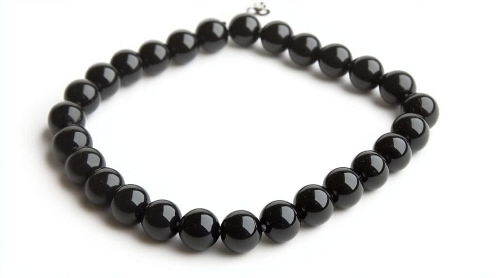 A polished basalt bead necklace with spherical stones arranged in a classic design on a white background.