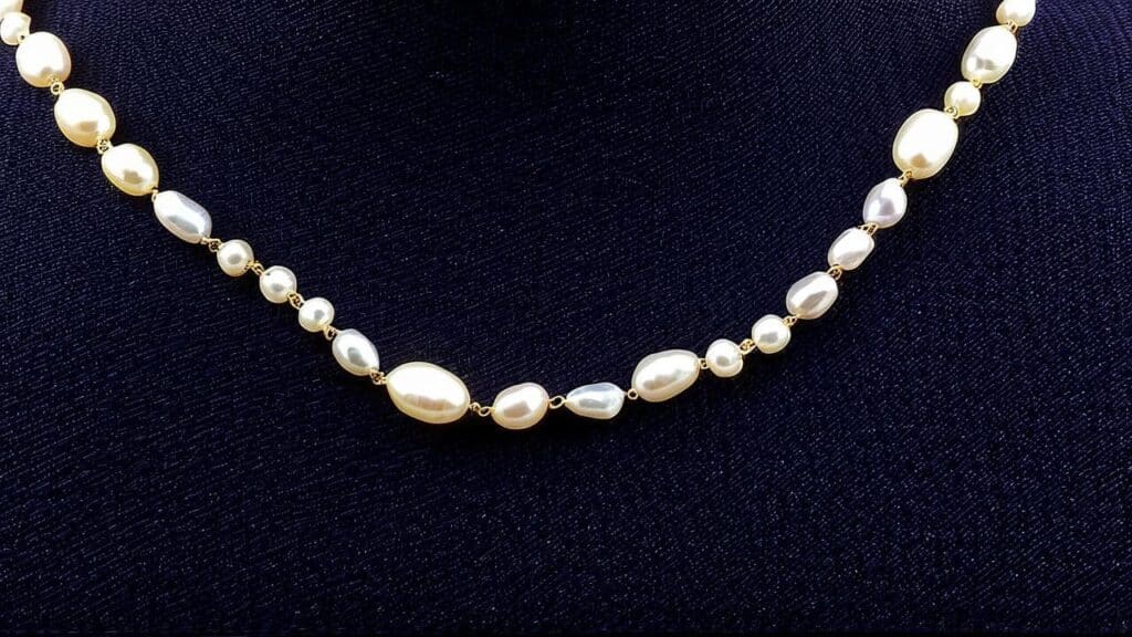 A pearl necklace featuring bleached pearls with a uniform white color and enhanced luster due to gemstone bleaching.