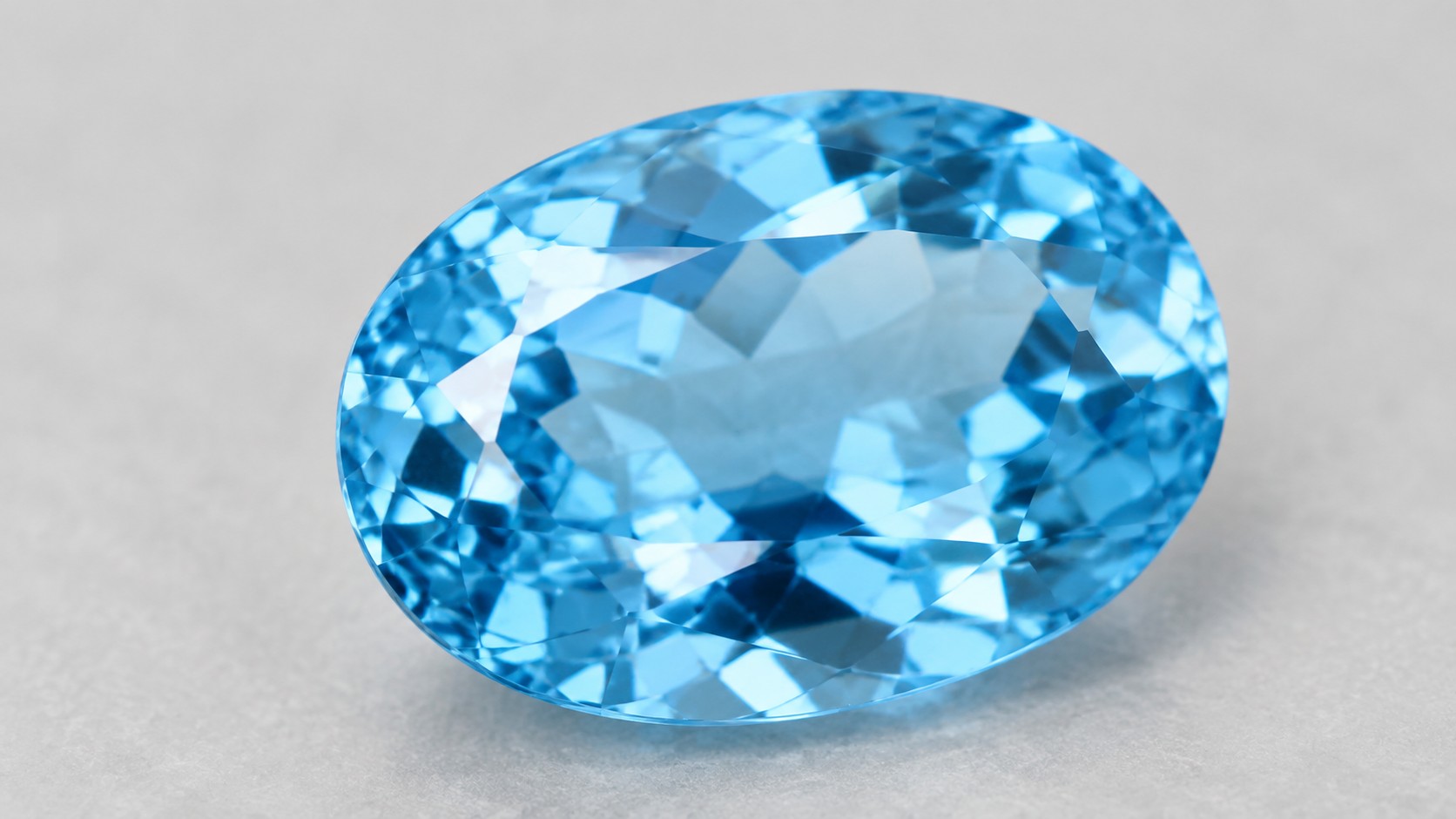Faceted sky blue topaz gemstone on a neutral background