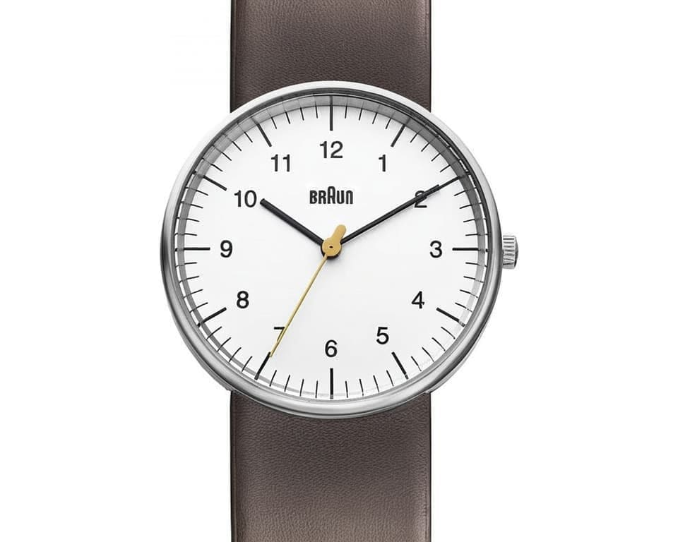 Braun watch with white dial and brown leather strap displaying yellow seconds hand and numbered markers in authentic Bauhaus style