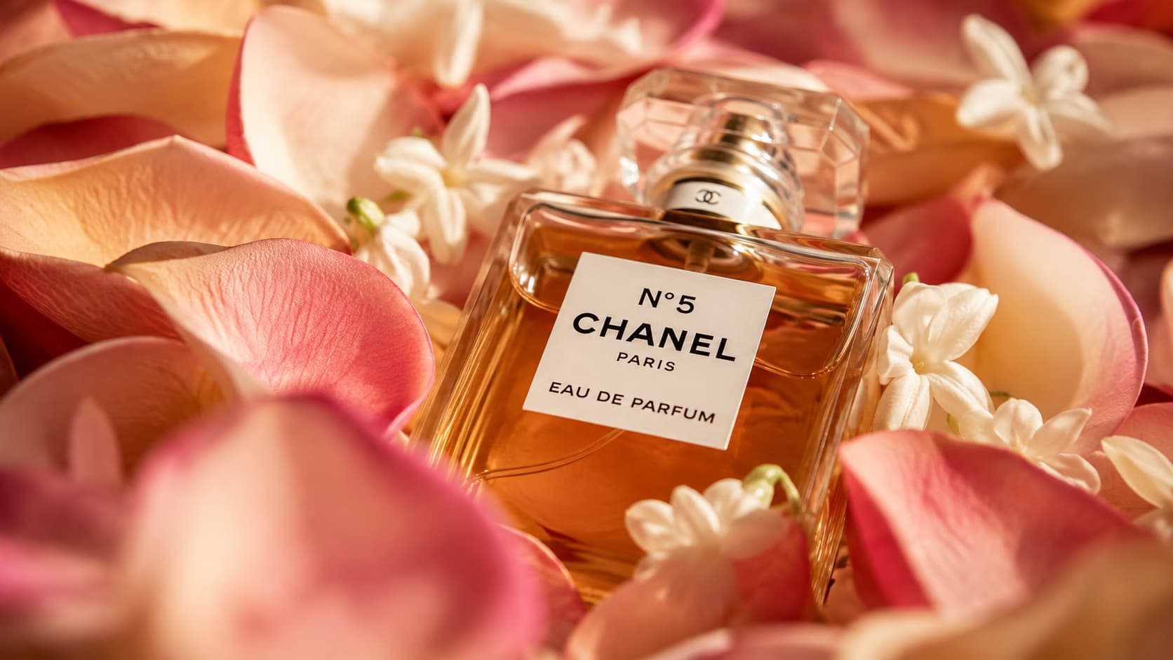 Chanel No. 5 bottle surrounded by rose and jasmine petals, representing floral middle notes