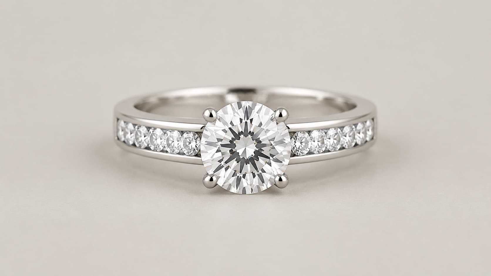 Round diamond in a prong setting with channel-set side stones on a white gold engagement ring