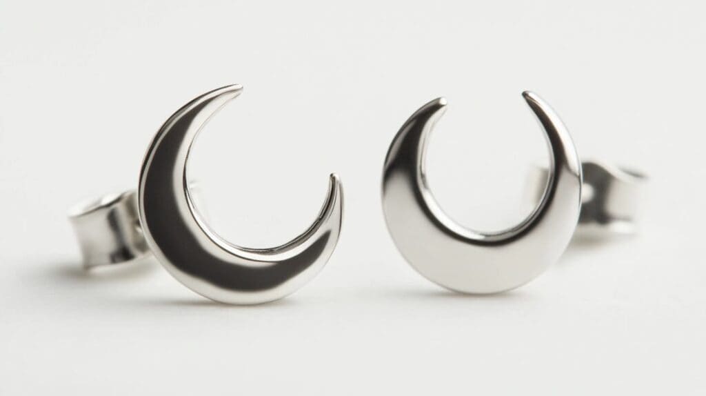 Pair of silver crescent moon stud earrings with a polished finish, displayed on a white background.