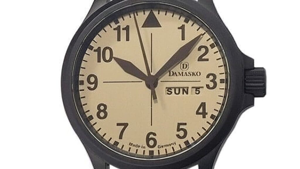 Damasko watch featuring cream colored dial with day-date complication, Arabic numerals, and black ice-hardened steel case demonstrating German watchmaking craftsmanship