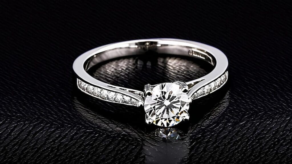 A classic diamond engagement ring set in a white gold band with accent diamonds, showcasing brilliance and timeless elegance.