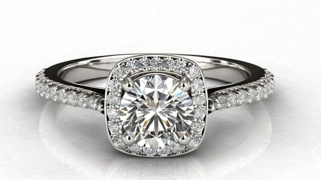 White gold diamond engagement ring featuring cushion cut center stone surrounded by halo of smaller diamonds and pavé band, demonstrating pointer weight in accent stones