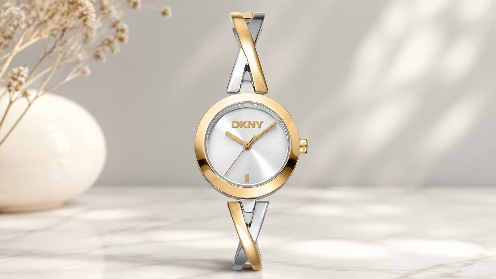 DKNY ladies gold and silver half bangle watch with round dial