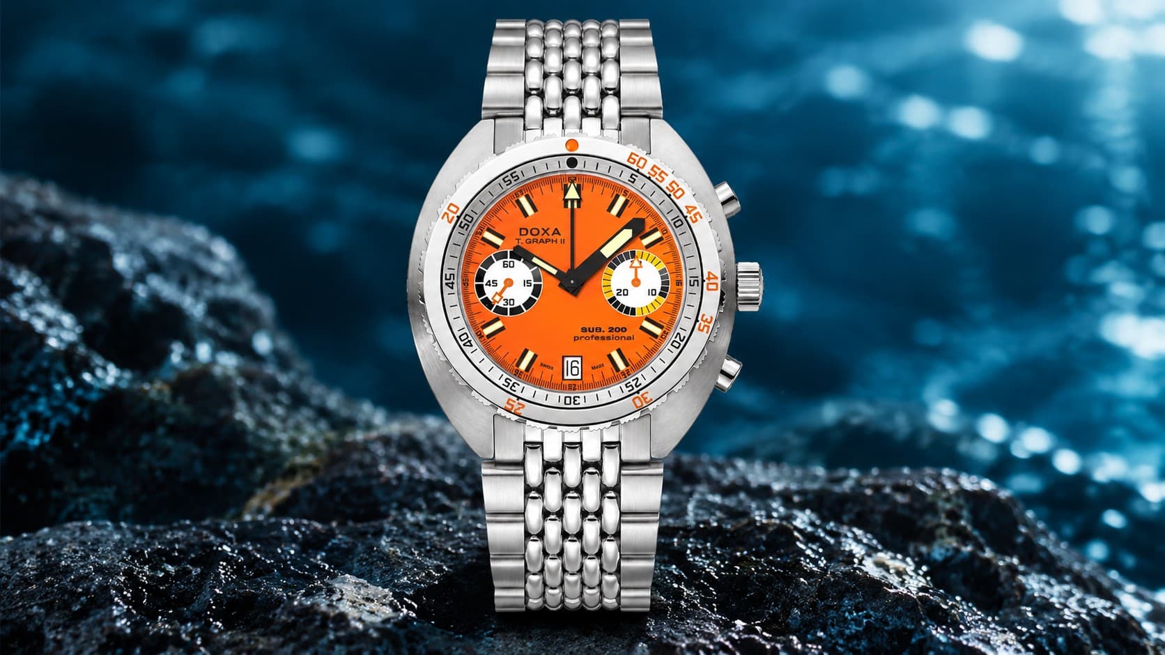 Doxa SUB 200 T.GRAPH II Professional chronograph dive watch with an orange dial and steel bracelet on wet dark rocks by the sea