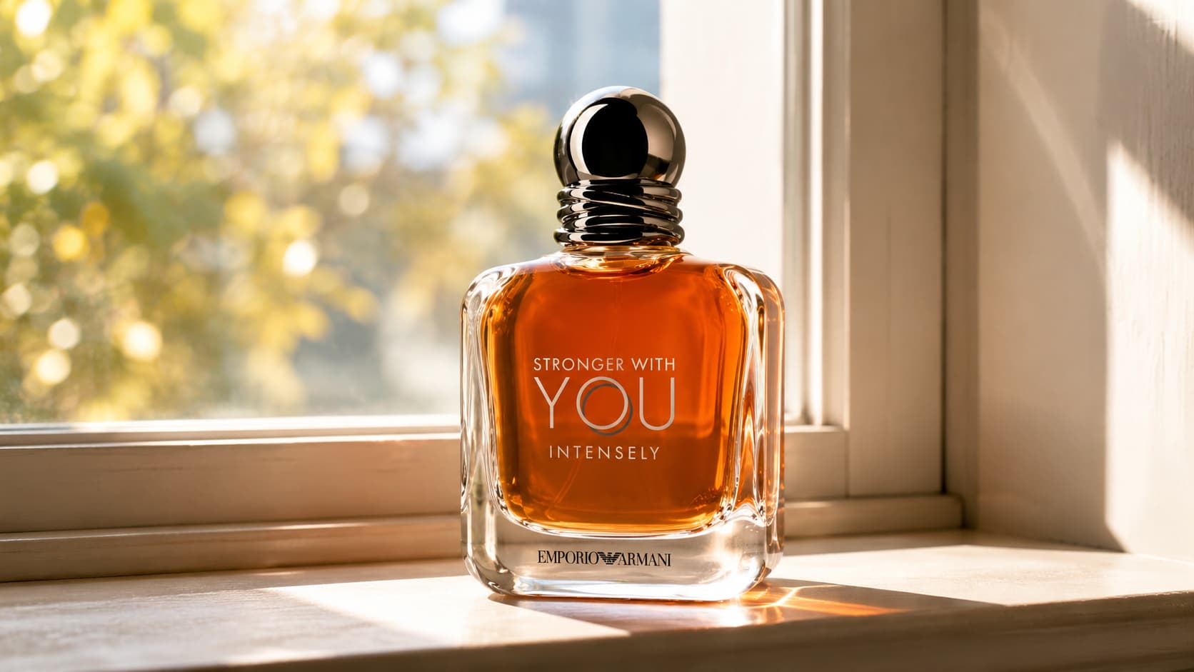 Emporio Armani Stronger With You Intensely perfume bottle sitting in direct sunlight on a windowsill