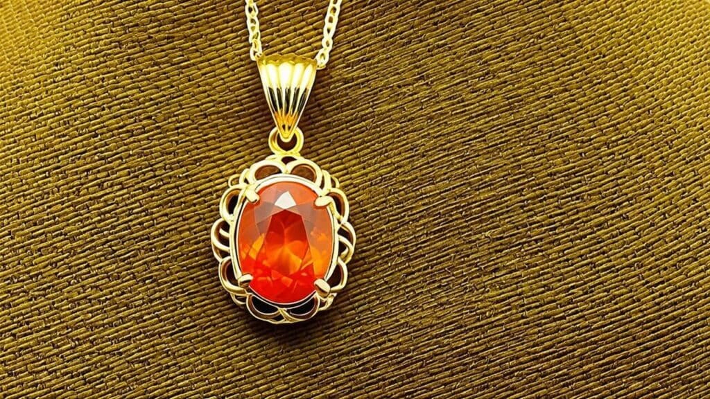 Gold pendant featuring fire opal gemstone with vibrant orange and red colors symbolizing the fire element