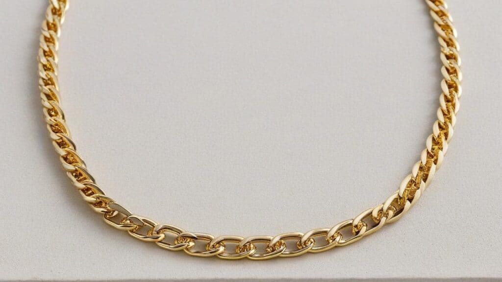 Yellow gold chain necklace on light background - may contain nickel alloys that cause metal allergies