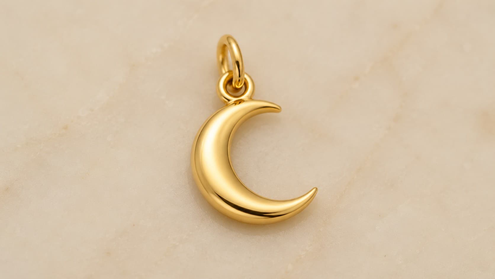 Gold crescent moon charm symbolizing change and growth