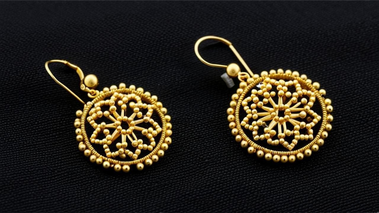 Round gold earrings covered in tiny granulated beads forming a starburst