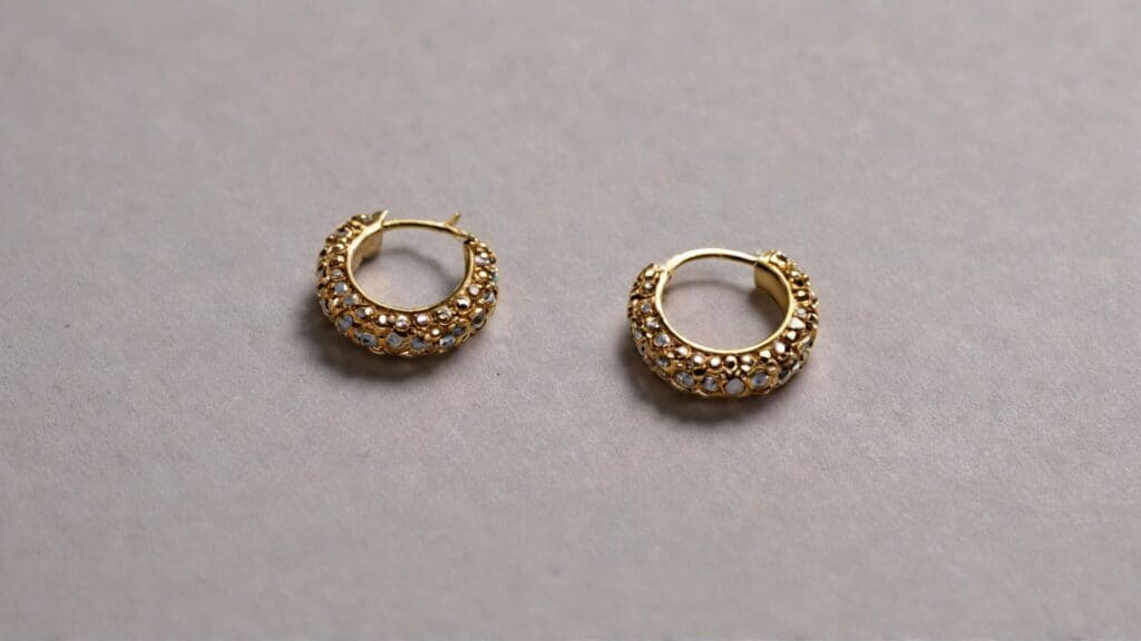 Gold hoop earrings with crystal details showing secure closure mechanism to prevent earring loss