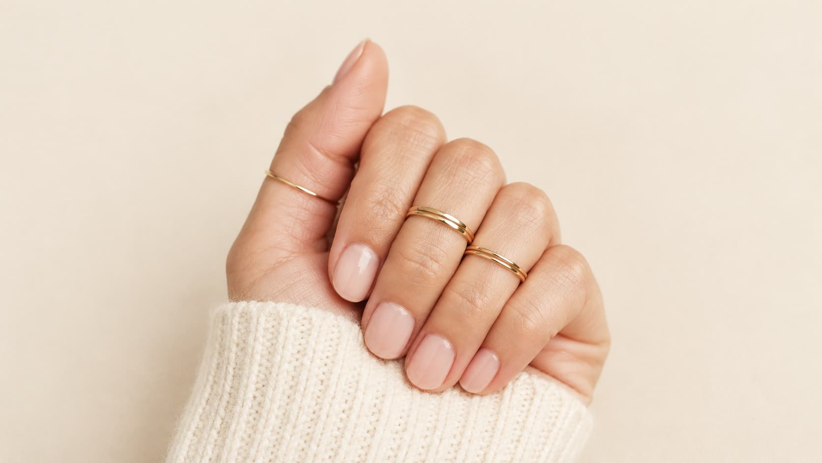 A thin gold midi ring worn above the knuckle