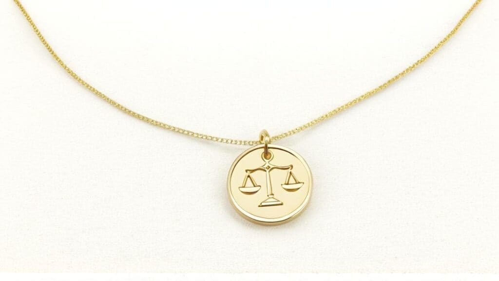 Gold medallion pendant necklace featuring the scales of justice, symbolizing Libra's quest for balance