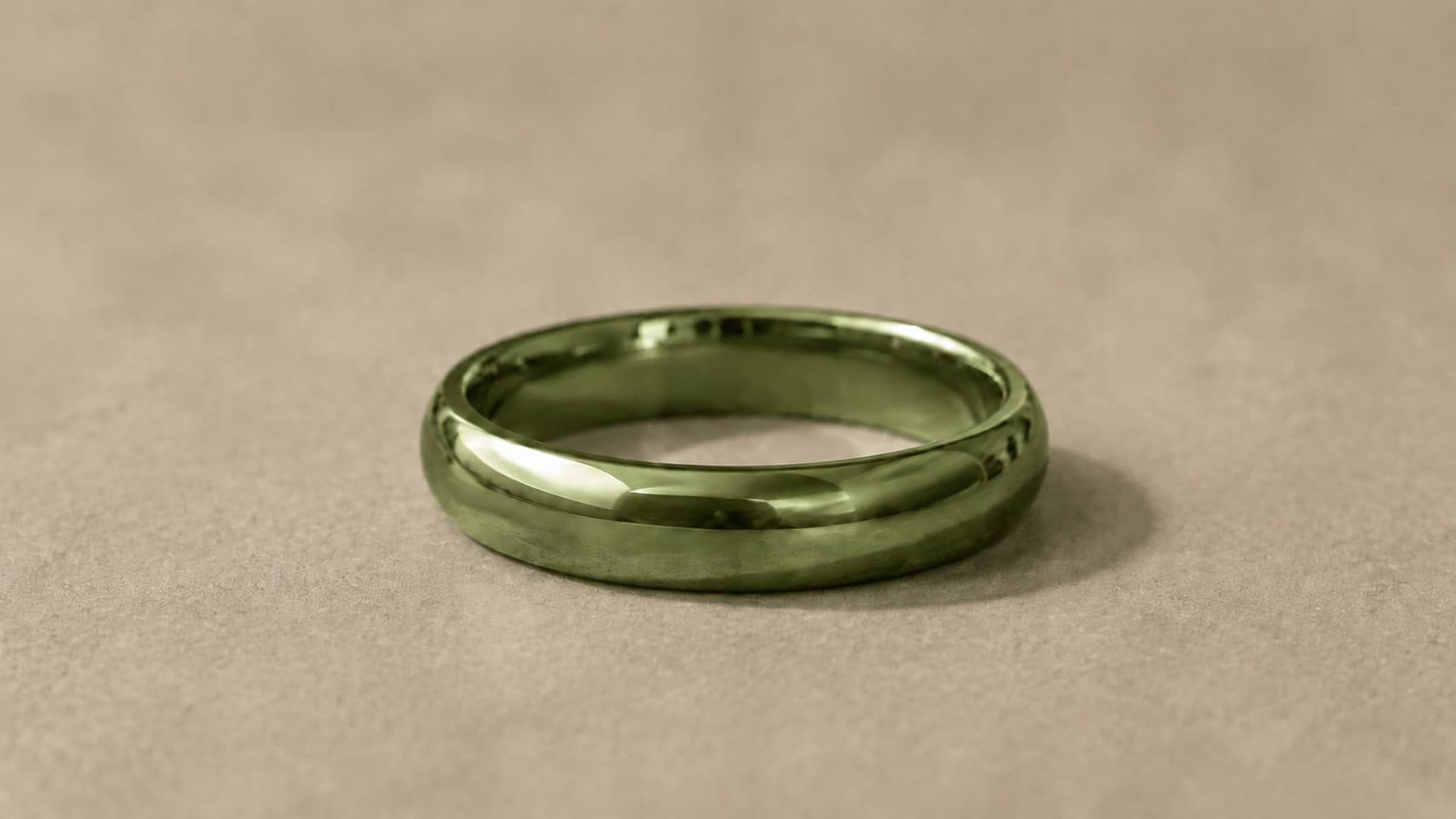 Close-up of a green gold ring showing its color on a neutral beige background