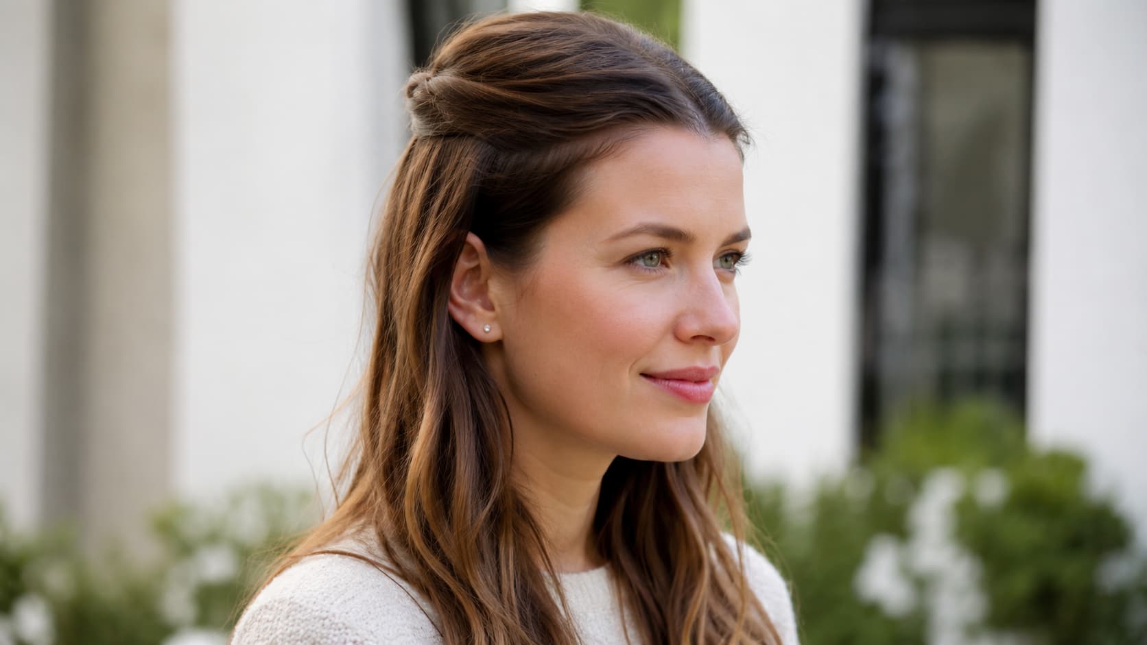 Woman with a half-up hairstyle wearing a small stud earring
