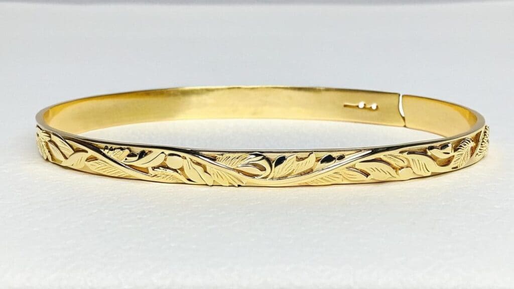 Traditional Hawaiian gold bracelet featuring engraved maile leaf design symbolizing honor and connection