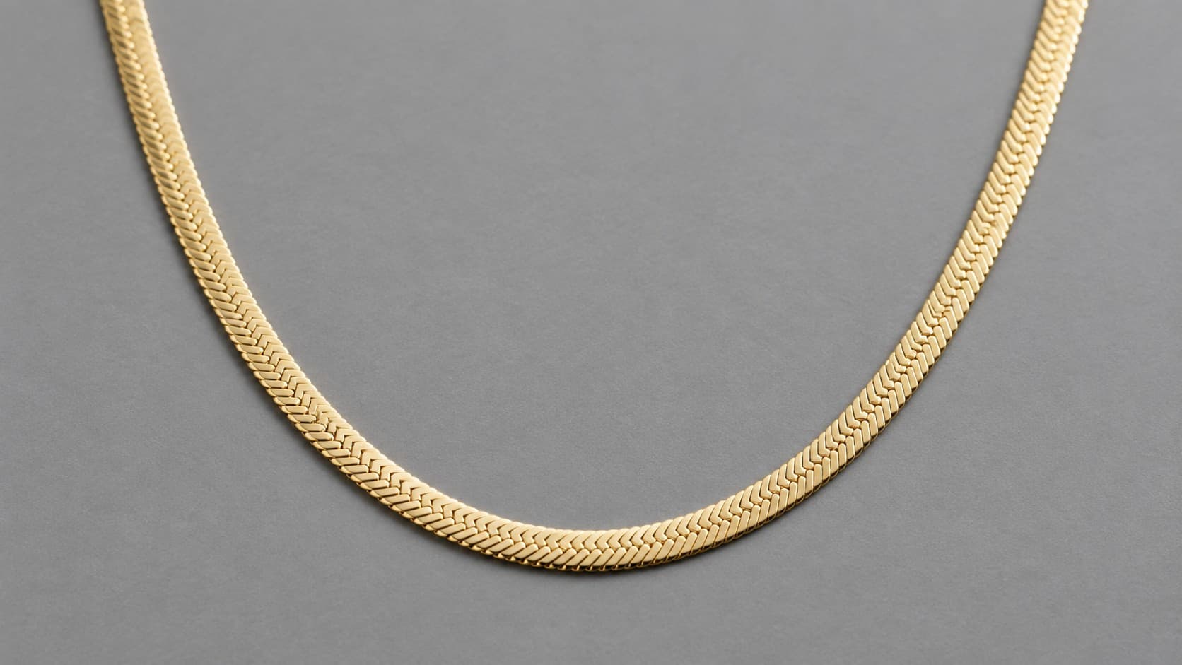 Gold herringbone chain necklace with a flat woven zigzag pattern