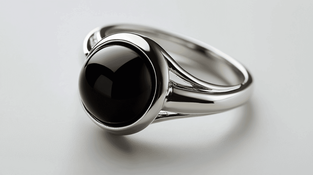 A sleek silver ring featuring a round cabochon jet gemstone with a deep black shine.