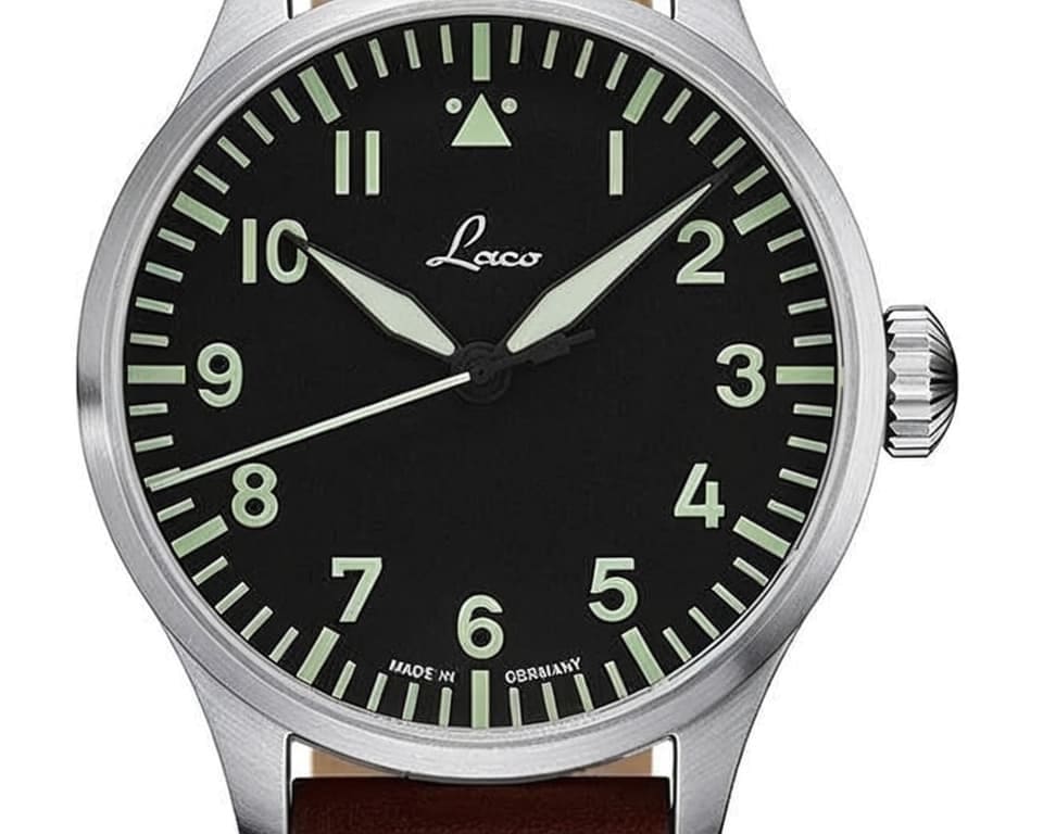 Laco pilot watch featuring black dial with luminous green markers, distinctive triangle at 12 o'clock position, and German aviation heritage design