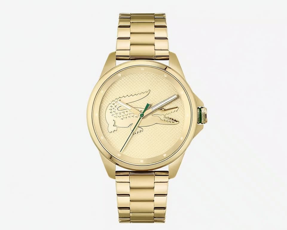 Lacoste gold-tone watch with oversized embossed crocodile logo on textured dial, matching gold steel bracelet and green accent hands