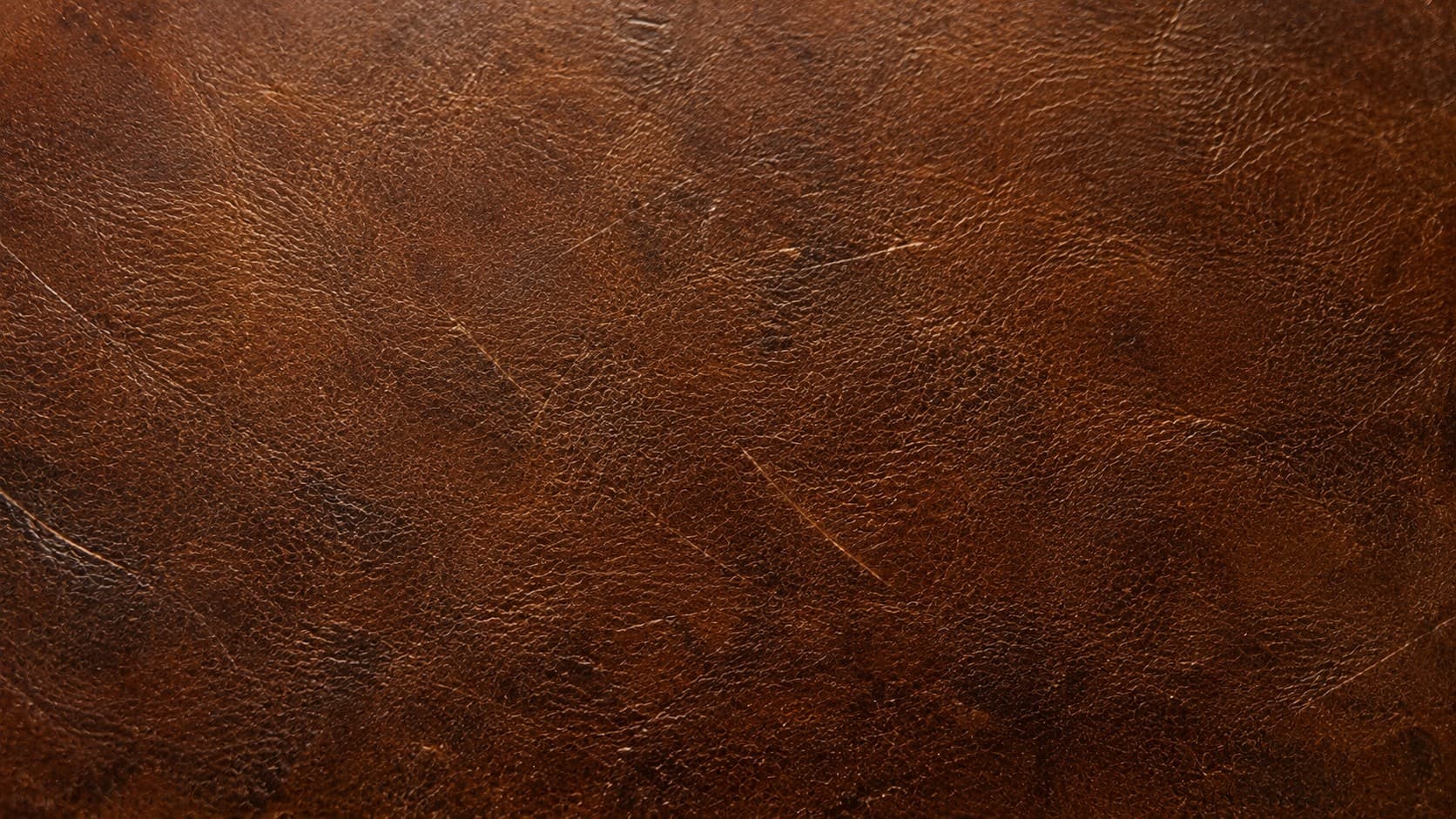 Close-up of aged brown leather showing natural texture and patina