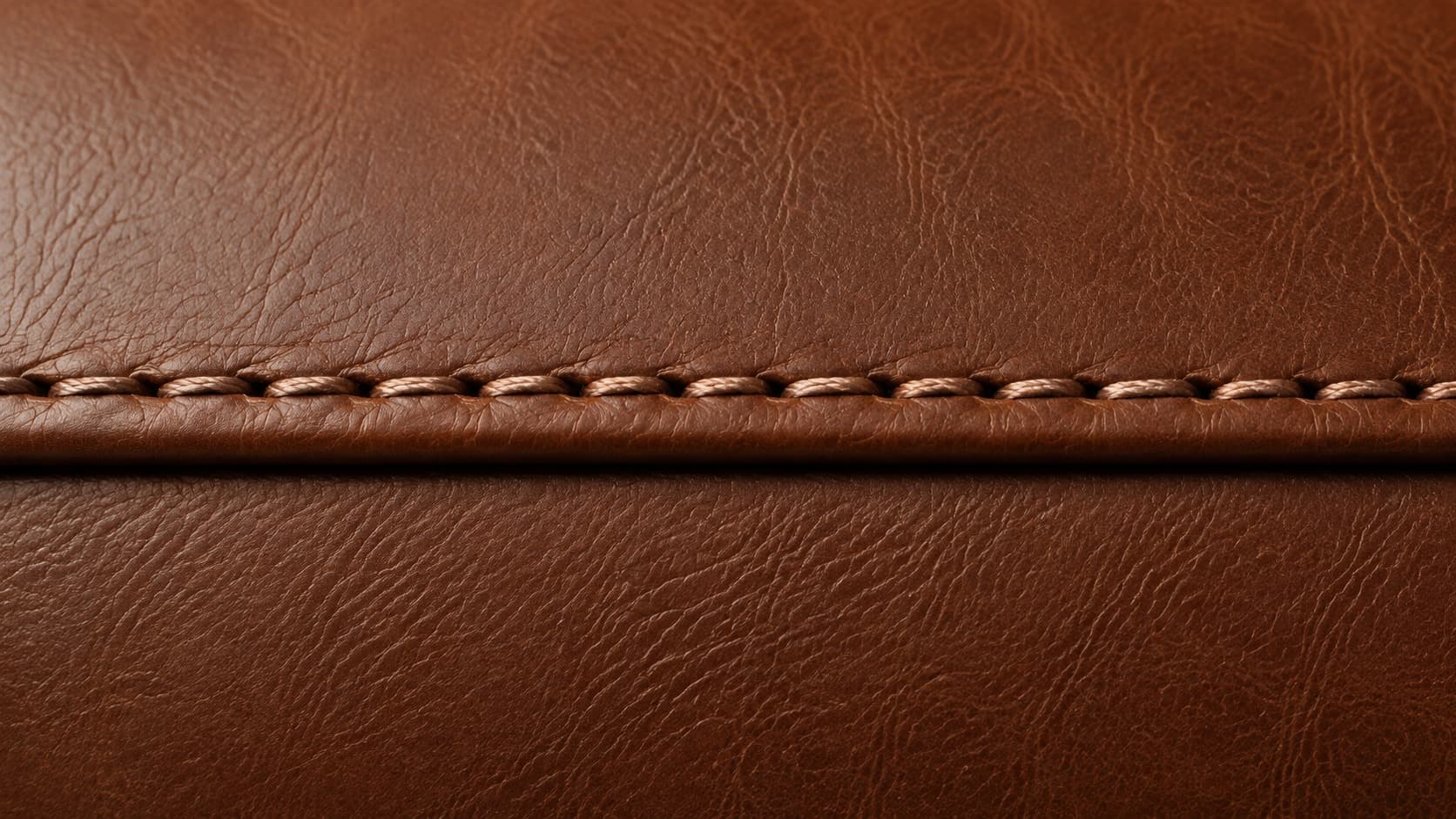 Close-up of a single stitched seam on brown leather