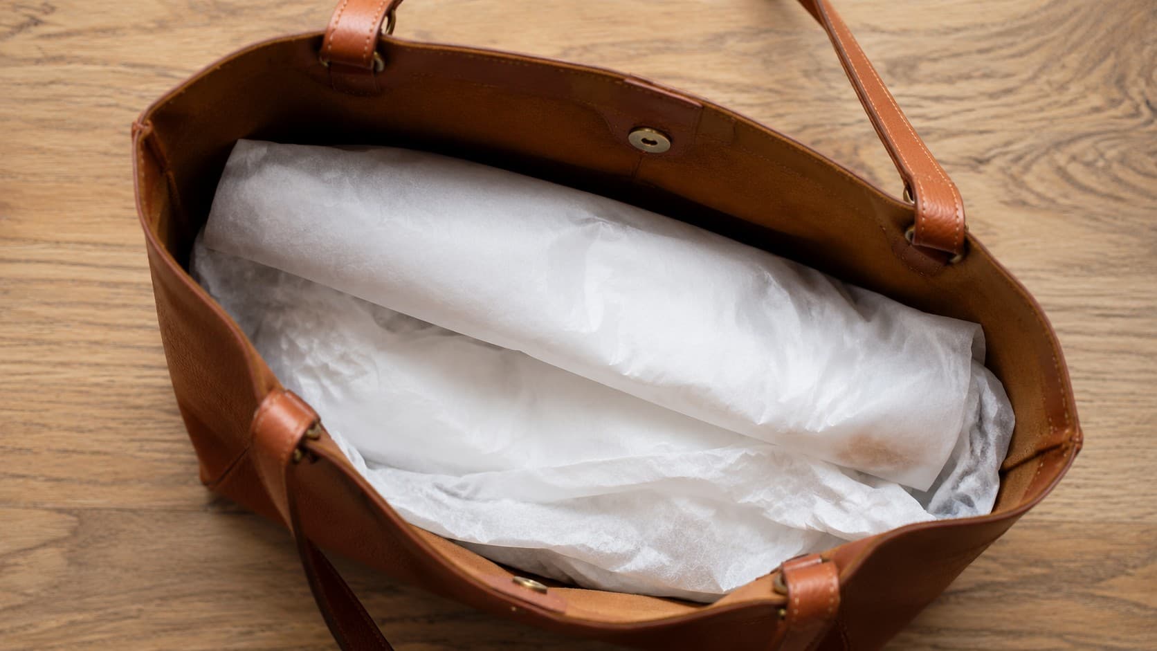 Leather tote bag stuffed with tissue paper to hold its shape in storage