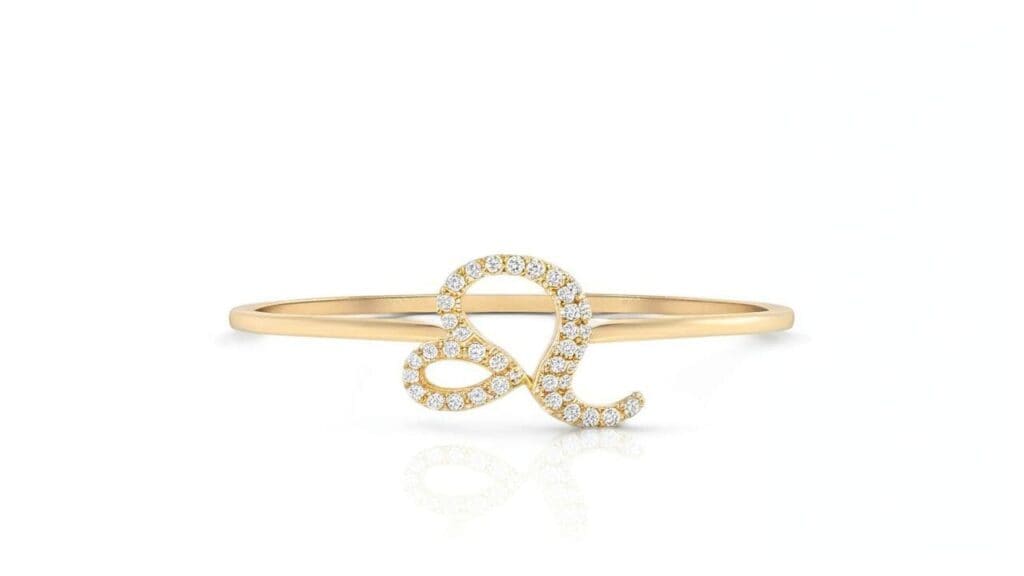 Delicate gold Leo zodiac ring with diamond-encrusted Leo symbol on thin band
