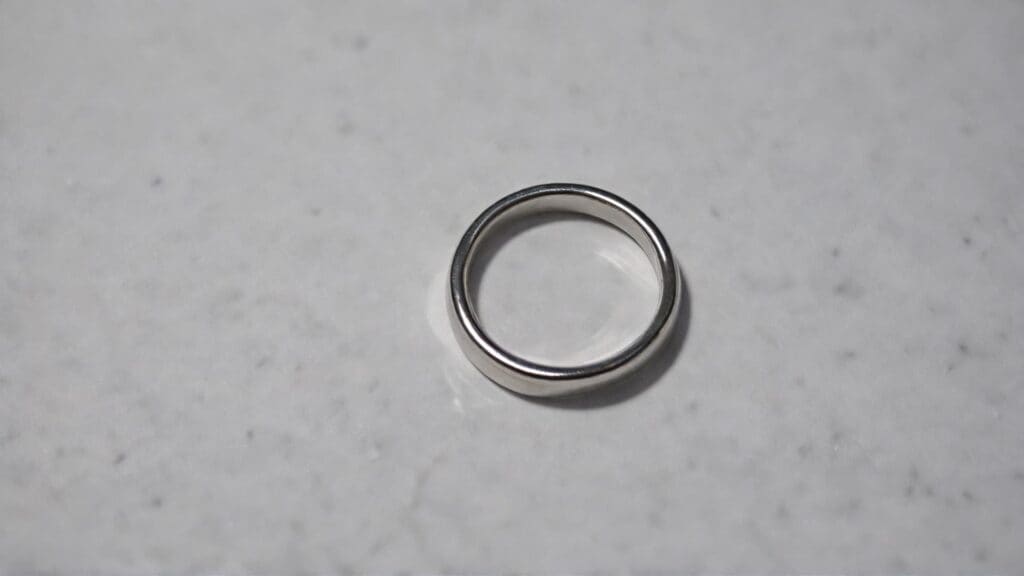 A minimalist silver divorce ring resting on a white surface, representing simplicity, clarity, and a fresh start after divorce.