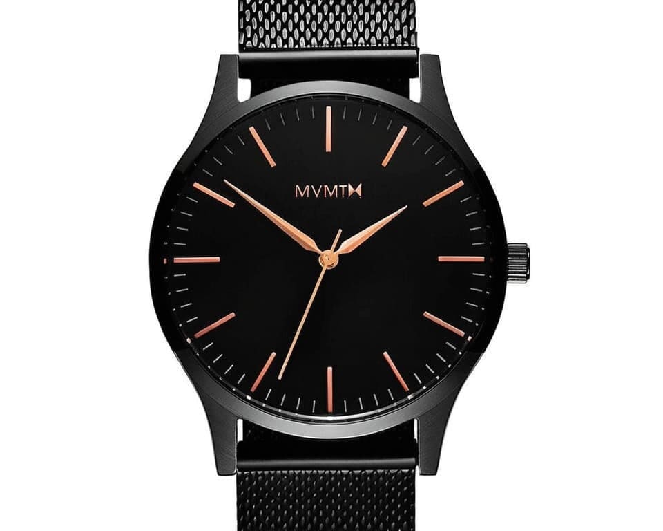 MVMT watch with black dial, rose gold hands, and black mesh bracelet showing minimalist California design