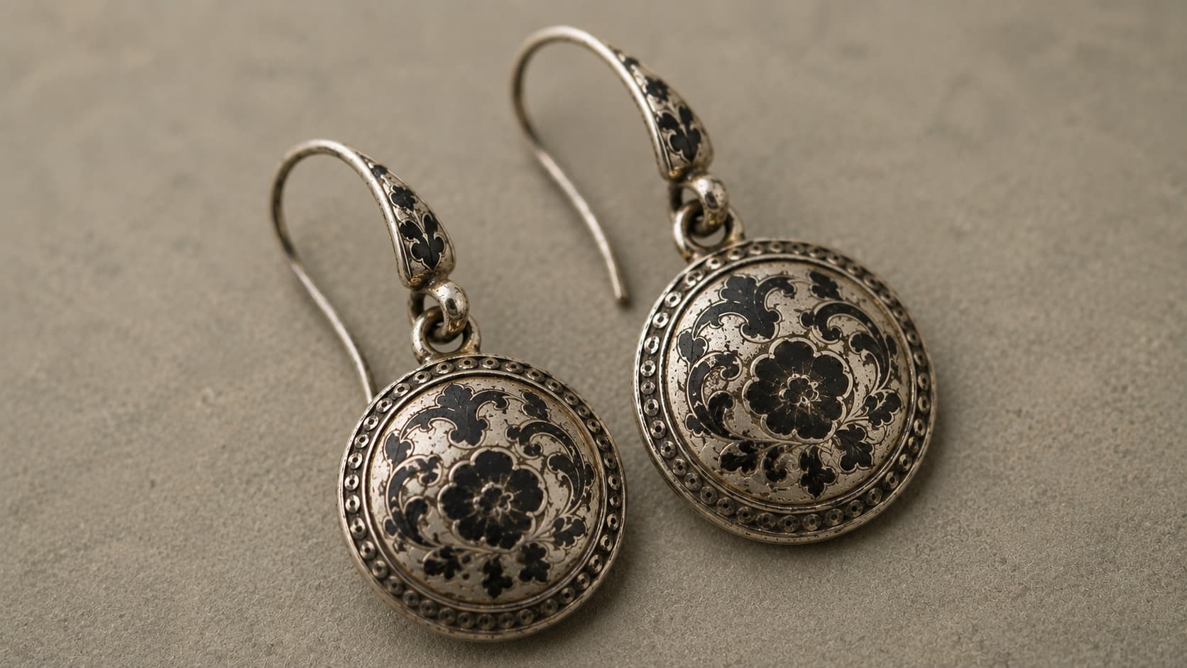 Silver earrings with black niello inlay in a floral scroll pattern