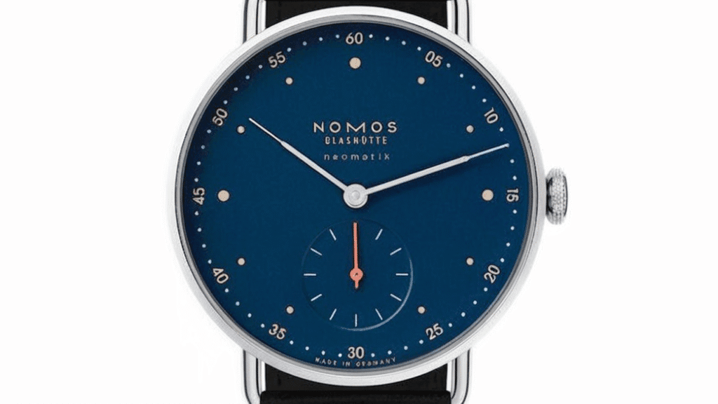 Nomos Glashütte Metro Neomatik featuring striking midnight blue dial with gold dot hour markers, automatic movement and black leather strap demonstrating modern German watchmaking