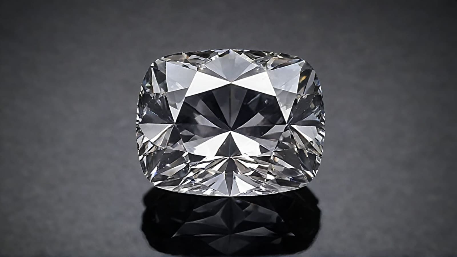 Cushion-shaped old mine cut diamond reflected on a dark grey surface
